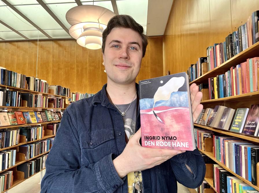 Mathias holder et eksemplar af bogen "Den røde hane".