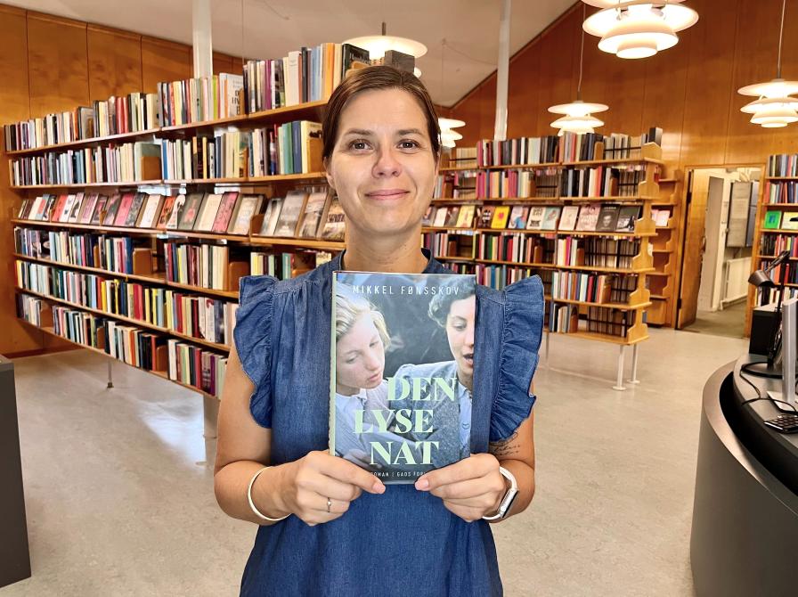 Bibliotekar Marianne Wismar Mühring med bogen "Den lyse nat".